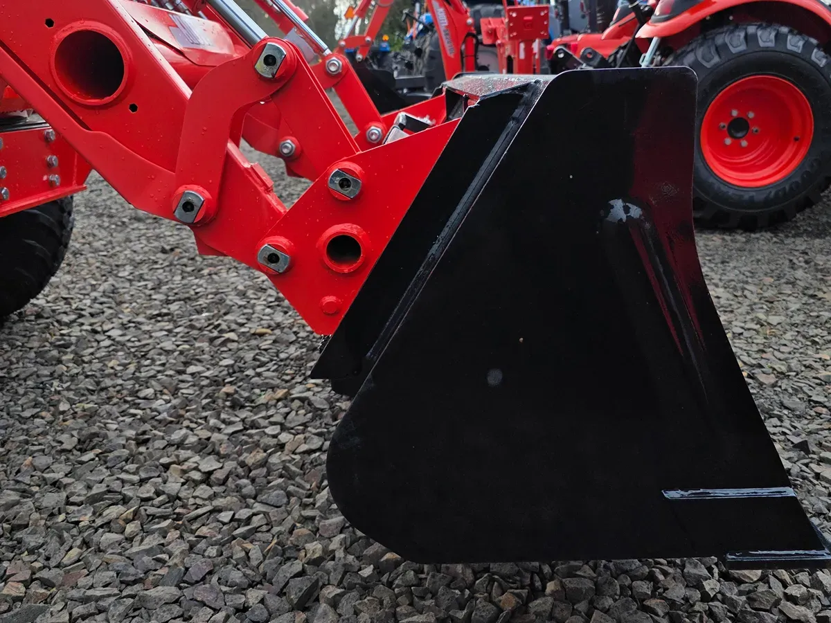 tractor front end loader side view showing the pivot pins in relation to the bucket and quick attach